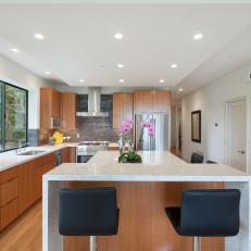 Modern Kitchen With Woodgrain Cabinetry and Eat-In Island