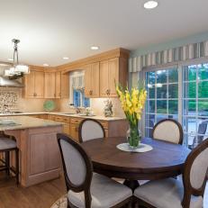 Contemporary Eat-in Kitchen with Light Wood Cabinets and Dark Wood Round Dining Table