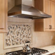 Kitchen with Diamond-shaped Tile Backsplash and Stainless Steel Range Hood