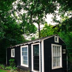 Exterior View of Cottage With White Trim and Full Length Windows 