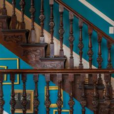 Victorian Staircase With Bold, Dark Wood, Turquoise Walls and Yellow Gold Picture Frames 