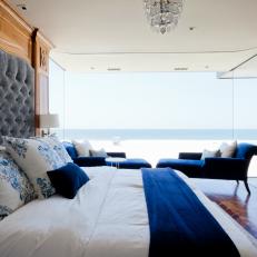 Seaside Master Bedroom with Large Windows, Blue Chaise Lounge Chairs, and a Built-in Headboard 