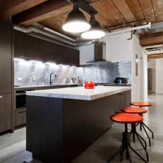Industrial Kitchen with High, Wood, Beamed Ceilings and Island with Carrera Marble Top and Red Bar Stools