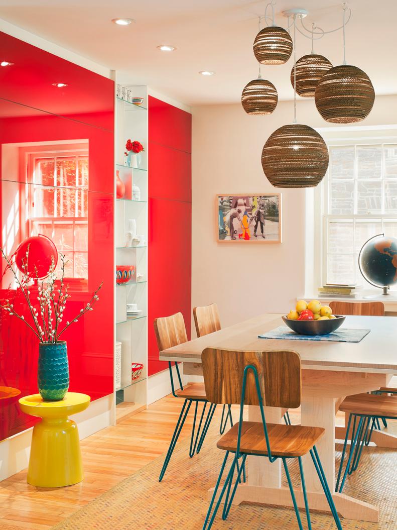 Contemporary White Dining Room With Red Wall and Brown Globe Pendants