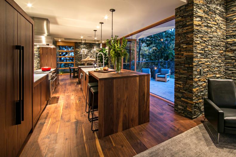 Galley Kitchen With Walnut Floors, Island and Stacked Stone Walls