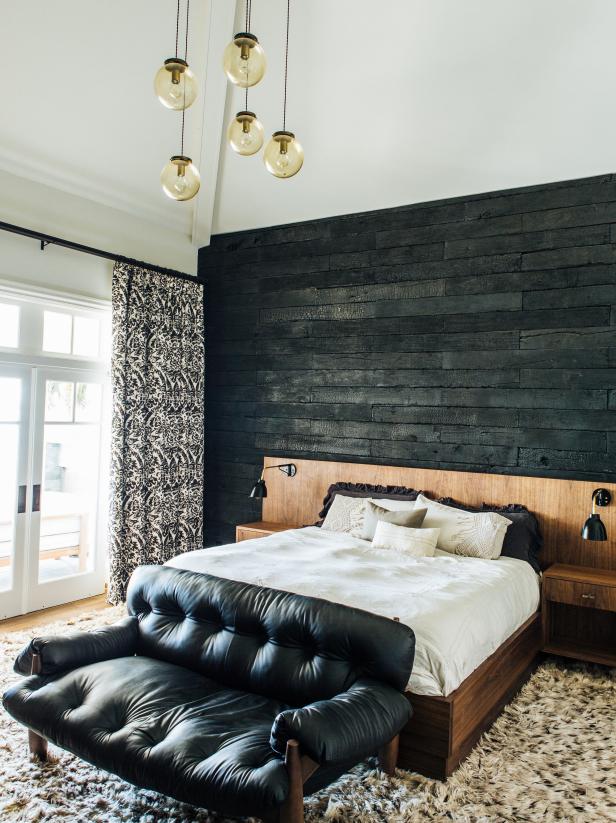 Neutral Bedroom With Black Wood Accent Wall and Small Black Sofa