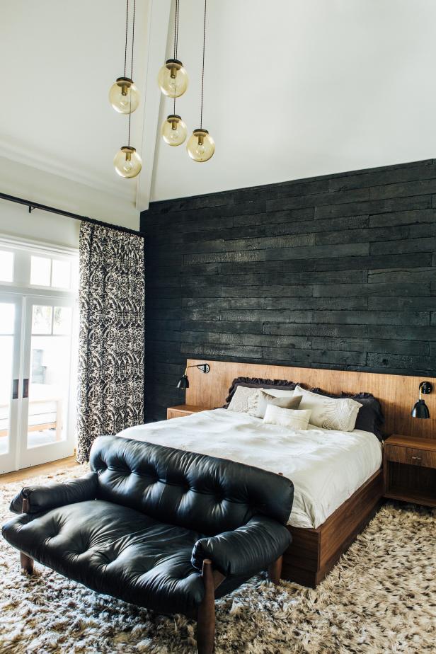 Neutral Bedroom With Black Wood Accent Wall and Small Black Sofa