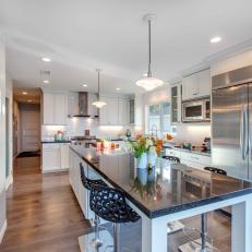 White Kitchen With Spacious Island and Stainless Steel Refrigerator