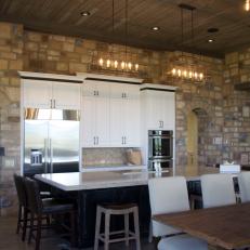 Eat-In Kitchen Features Stone Walls, Wood-Beam Ceiling & Metal Chandeliers