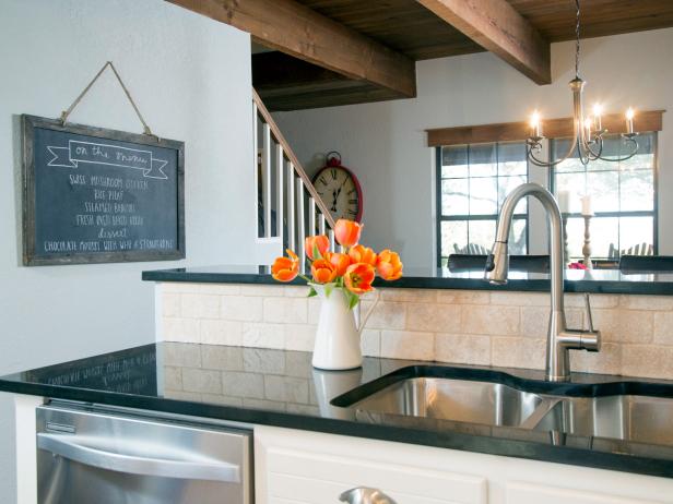 Hosts Chip and Joanna Gaines completely transformed the Jonklaasâ   kitchen by removing the wall to the dining room and creating a more open flow to the space.  A new natural stone backsplash, stainless steel appliances and fixtures were installed. A chalk board with tonight's dinner menu hangs between the kitchen and dining room, as seen on HGTVâ  s Fixer Upper.  (after)