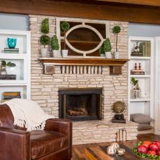 Built in Cabinetry, Textured Stone Fireplace Surround and Large Leather Armchair in Cottage Living Room