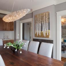 Narrow, Transitional Dining Room With Crystal Light Fixture, Long Wood Dining Table and Patterned White Chairs 