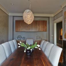 Sophisticated Contemporary Dining Room With White Patterned Chairs, Walnut Dining Table and Crystal Chandelier 