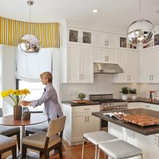 Gorgeously Bright Transitional Kitchen With Yellow Striped Valance, Silver Globe Lighting and Neutral Dining Set Up 