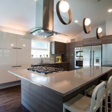 Contemporary Kitchen With Circle Pendant Lighting, Floating White Cabinet and L-Shaped Woodgrain Island