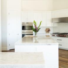 Contemporary White Kitchen With Stainless Steel Appliances and Glass Tile Backsplash
