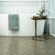Brown Herringbone-Patterned Floor Tile Showcases Modern Tub in Updated Bathroom