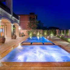 Glowing Neutral Marble Tile Pool Deck With Property Wall, Archways and Decorative Plants