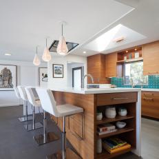 Geometric Pendant Lights, Woodgrain Cabinetry and White Leather Bar Chairs in Midcentury Modern Kitchen 