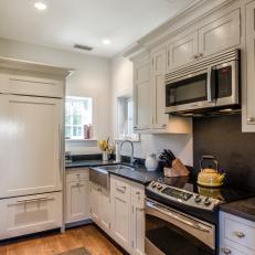 Cottage Kitchen With White Cabinets and Dark Countertops