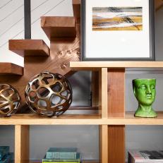 Shelving Unit Against Modern Stairs with Sculptures, Pictures and Books