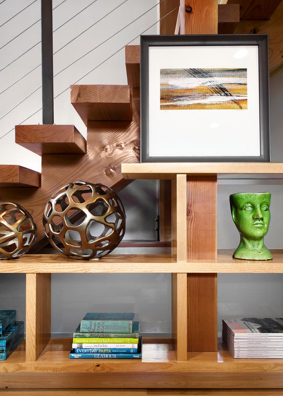 Shelving Unit Against Modern Stairs with Sculptures, Pictures and Books ...
