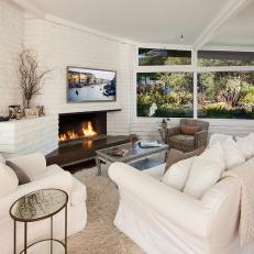 Cozy Living Room With White Brick Walls & Fireplace
