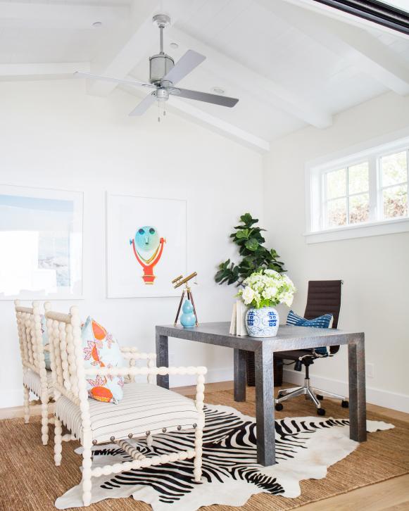 White Office Space With Zebra Hide Rug and Two White Chairs