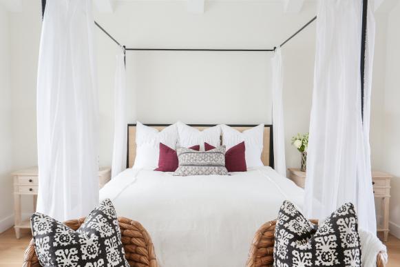 White Bedroom With Black Metal Canopy Bed and White Bedding