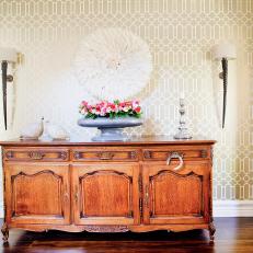 Hallway With Traditional Wood Sideboard, Patterned Wallpaper & Sconces