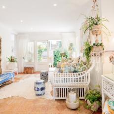 Bright, Coastal Living Room Features Large Mirror, Animal Hide Rug & Hanging Plants