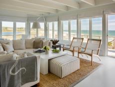 White, Coastal Living Room With Wall of Windows, Neutral Furniture