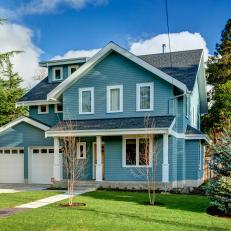Captivating Blue Farmhouse With White Trim & Gray Shingle Roof