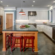 Bright, Contemporary Kitchen With Large Wood Island, Red Barstools and Concrete Floor