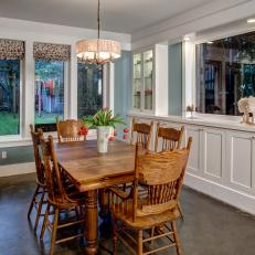 Country Dining Room With Wood Furniture, Built-In White Cabinets and Concrete Floor