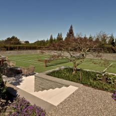 Tennis Court Surrounded by Manicured Gardens 