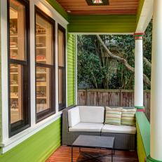 Front Porch With Lime-Green Walls and Wicker Loveseat 