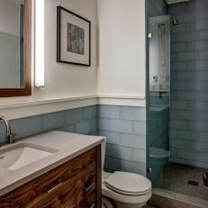 Bathroom With Wood Vanity and Light Blue Tile