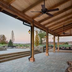 Covered Patio With Natural Wood Benches and Lantern Sconces 