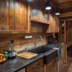 Kitchen Sink With Rustic Wood Cabinetry & Black Countertop