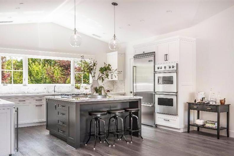White Kitchen With Gray Island and Glass Pendant Lights