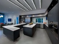 Large modern kitchen with family room in gray, black and white. 