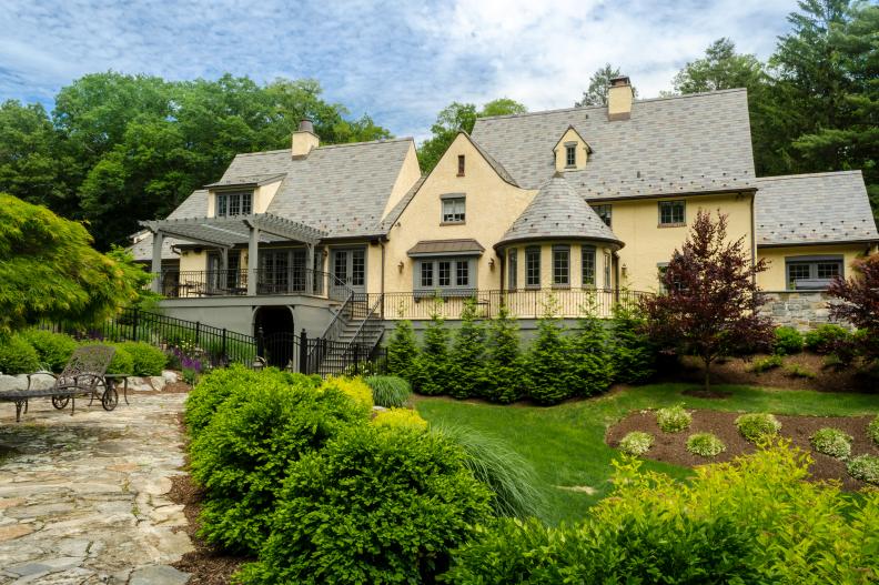 Tudor-Style Home With Back Porch and Stone Walkway