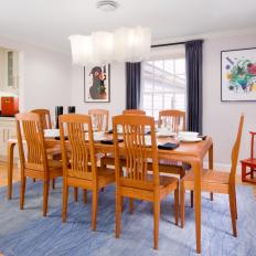 Contemporary Dining Room with Bright Wood Table and Chairs Plus Colorful Art