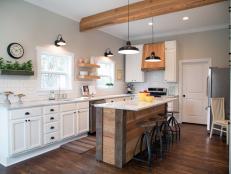 Fixer Upper Hosts Chip and Joanna Gaines turned the once disastrous room into a bright, clean kitchen with new cabinets, wood floors, Carrera marble countertops and light gray paint with white trim.  The old drop ceiling was removed, adding height to the room, and a wooden support beam was added.  A subway tile backsplash, floating wood shelves, and stainless steel appliances were also installed. Client Clint Harper added the finishing touches to the kitchen by making a beautiful island and vent hood out of reclaimed wood , as seen on HGTV's Fixer Upper.  (After 7a)  Afters