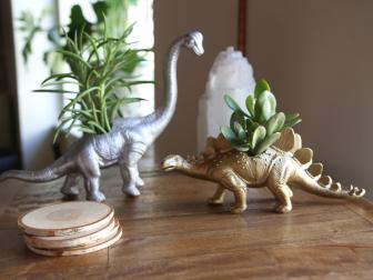 Make miniature dinosaur planters using metallic paint and animal figurines.