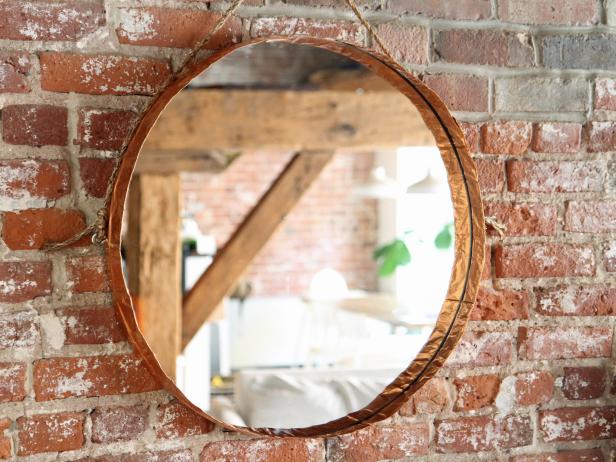 Make a hanging round mirror with copper edging to add a stylish touch to any room in your home.