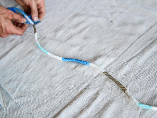 Remove painter's tape from rope after paint drys.