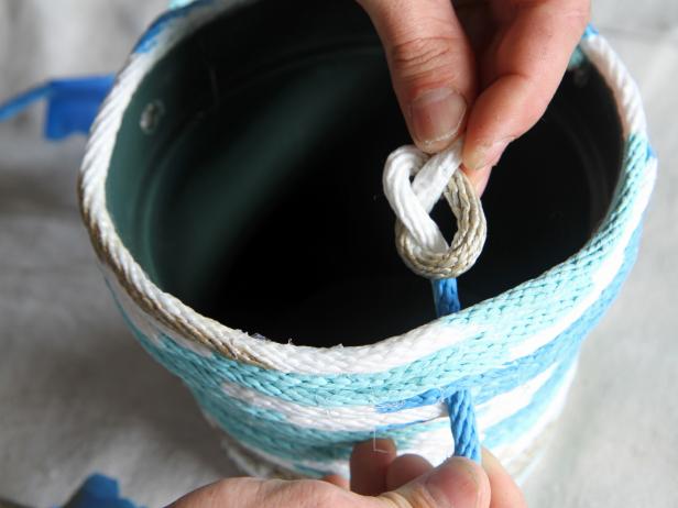 Tie a knot in the rope on the inside of the pot, leaving approximately three feet of rope.