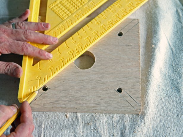 Use a square to draw a line on each side of the drilled holes to each of the corners of the wood block.